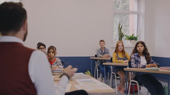 Teacher Actively Talking to Elementary Kids and Children Laugh with Him