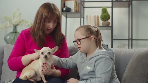 Cute Daughter with Genetic Disease Mom and Dog Relaxing on Sofa