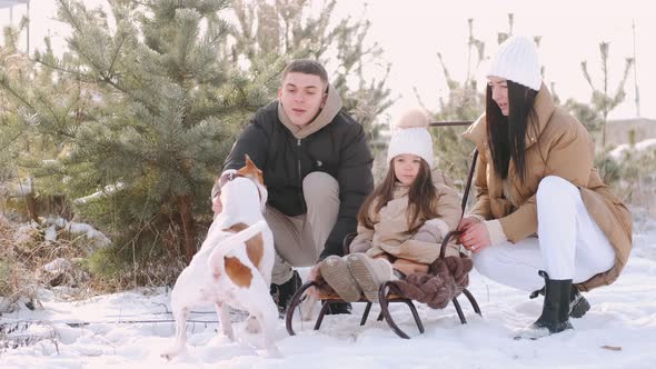 Young Family Walking Near Forest in Countryside in Winter