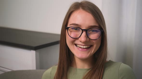 Confident Laughs Young Woman in Glasses Looking at Camera Standing at Home Office