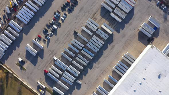 carrier company huge truck containers fleet in parking warehouse, orbital aerial