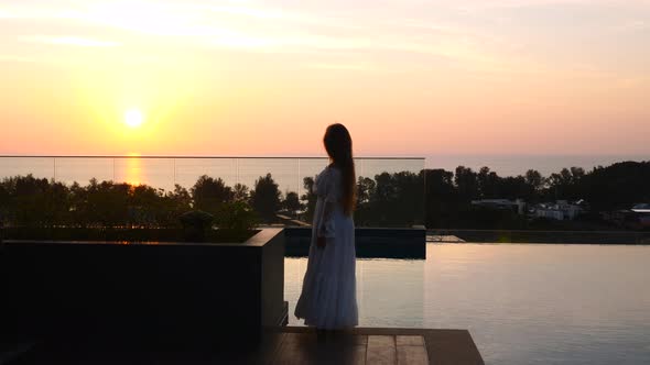 Travel Woman Standing on Rooftop with Sunset Sky View Relax and Dancing