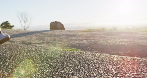 Low section of african american woman exercising outdoors running in country side during sunset