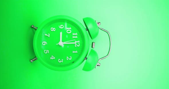 Green Classic Alarm Clock on a Green Background Rings at 9 AM  Vertical Video with Sound