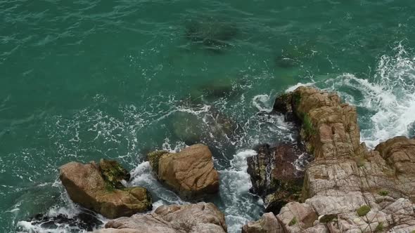 Top view sea with rocks. The waves hits the rocks in the sea. It's from Calella.