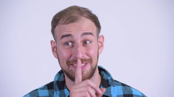 Face of Happy Bearded Hipster Man with Finger on Lips