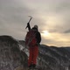 The Silhouette of a Young Male Climber Standing on Top of a Mountain and Holding Up an Ice Axe - VideoHive Item for Sale