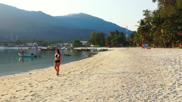 Beautiful women sunbathing on tropical coast beach journey by blue green lagoon with white sandy bac