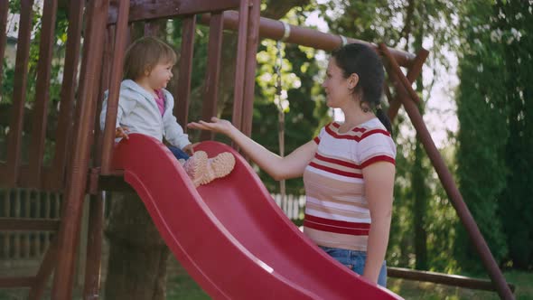 Mom Helps Her Daughter Get Off the Slide