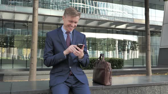 Happy Businessman Using Smartphone for Reading Email