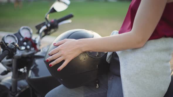 Beautiful Young Redhaired Woman Motorcyclist with Her Motorcycle and Helmet