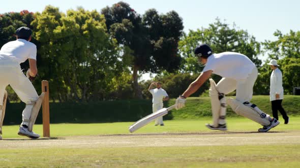 Fielder throwing ball to wicket keeper during cricket match
