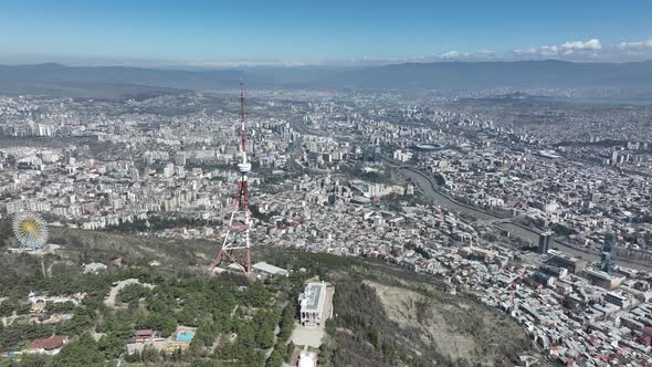 Aerial view of TV Tower in Mtatsminda park. Against the background of the city. Tbilisi, Georgia