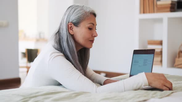 Pensive Asian woman reading book