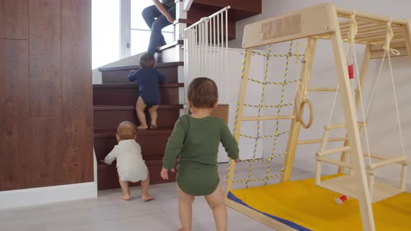Toddler Triplets Climbing up Staircase towards Mom alt