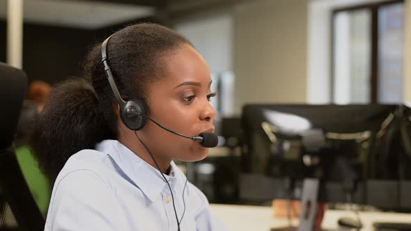 African Young Woman Talking to a Client on a Headset