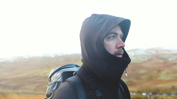 Portrait of a man hiking in winter and taking a break to enjoy the view