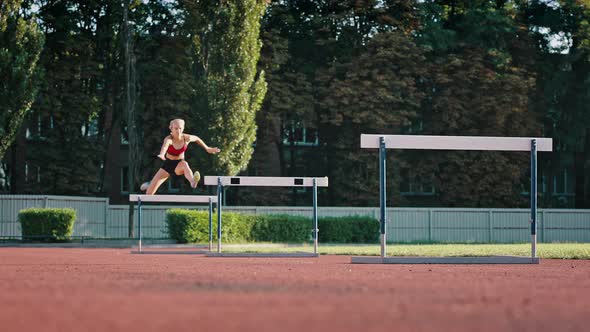 Professional Female Athlete Overcomes Obstacles By Jumping Over Them