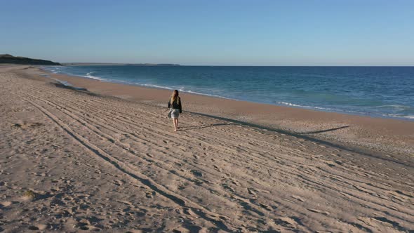 Young woman walking along beautiful tropical sandy beach