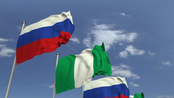 Flags of Nigeria and Russia Against Blue Sky