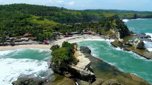 Waves breaking on Big rock at Klayar beach, East Java in Indonesia. Aerial circling