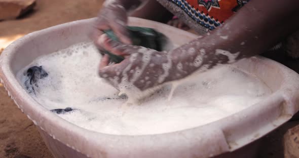 African woman washing laundry by hand