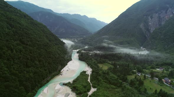 Aerial view of Soca river surrounded by hills in Slovenia.