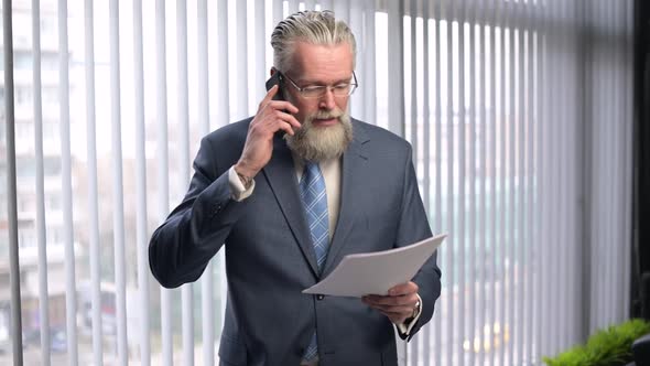 A mature gray-haired company executive calls the office to discuss the contract