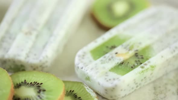 Kiwi coconut chia popsicles on granite board.