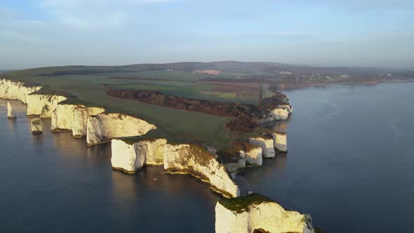 Old Harry Rocks cliffs and green English countryside, Dorset in England. Aerial forward