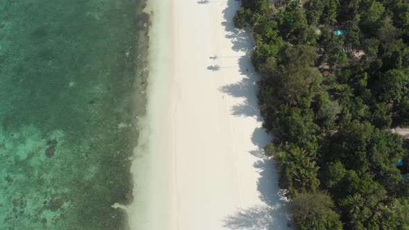 Aerial: flying over white sand beach tropical sea Kei Islands Indonesia