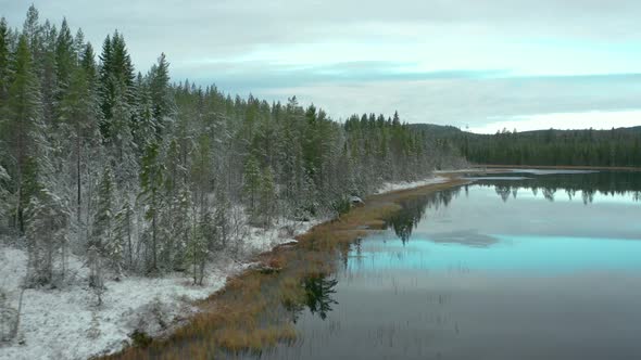 A freezing lake in Sweden, cinematic aerial tracking daylight shot