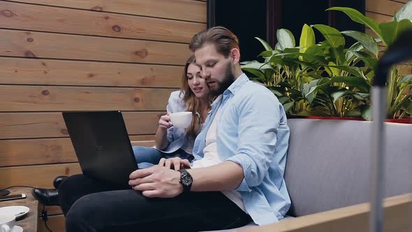 Man and Woman which Sitting Together in Lobby and Using Laptop