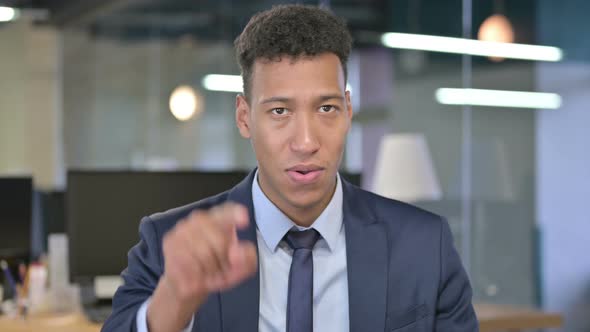 Portrait of Young Businessman Pointing Finger and Inviting