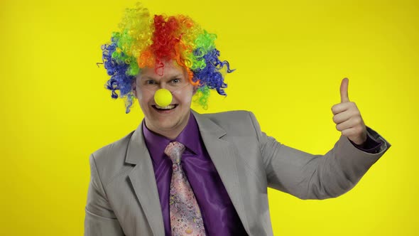 Clown Businessman Entrepreneur Boss in Wig Show Thumb Up. Yellow Background