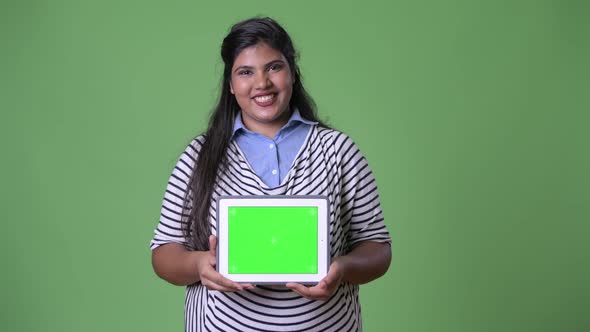 Young Overweight Beautiful Indian Businesswoman Against Green Background