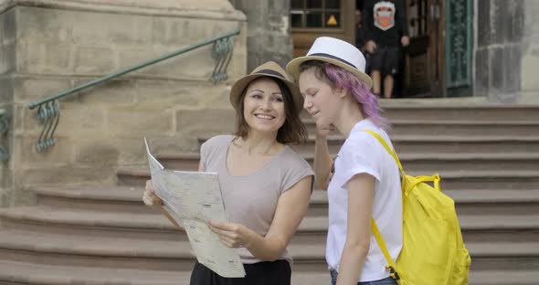 Mother and Teenage Daughter in Old Tourist City with Map