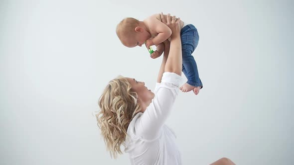 Single Parent, Motherhood and Babyhood Concept - Mother Holding Sweet Baby Girl on White Background