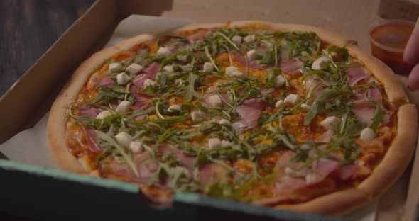 Talented Italian Chef Serving a Delicious Traditional Mozzarella Pizza Topped with Fresh Basil