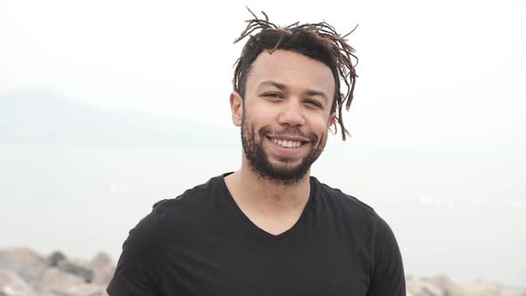 A rasta hair mixed race young man laughing.