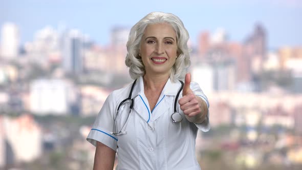 Happy Female Doctor Giving Thumb Up To Camera