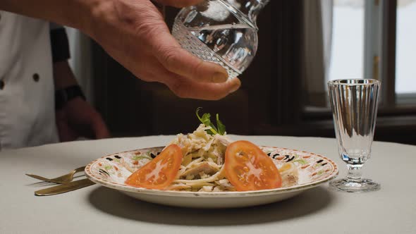 Waiter Pouring Vodka From a Crystal Decanter