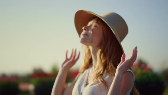 Pretty Girl Taking Off Sunhat in Summer Day