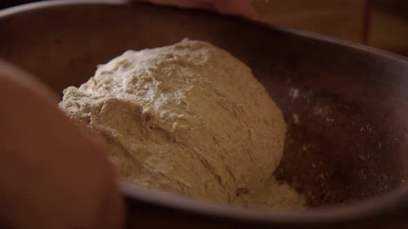 BAKING - Kneading sourdough bread dough, turning bowl, slow motion close up