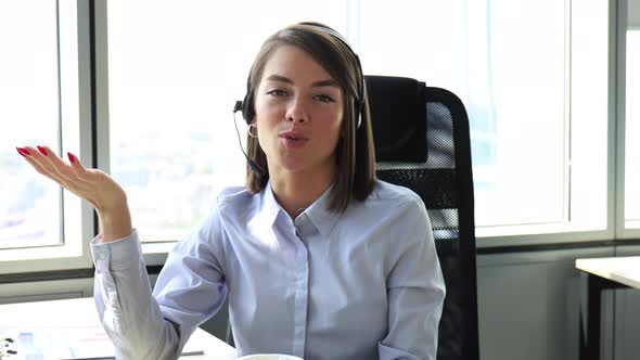 Young call operator businesswoman wears headset customer service manager looking