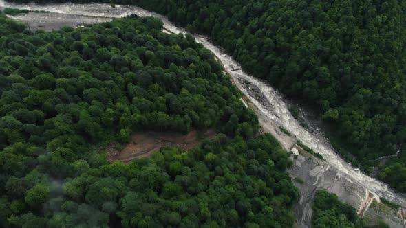 Top Down View of Fast Moving River with Rapids Surrounded By Pine Forest. Shot in Sochi. Aerial View