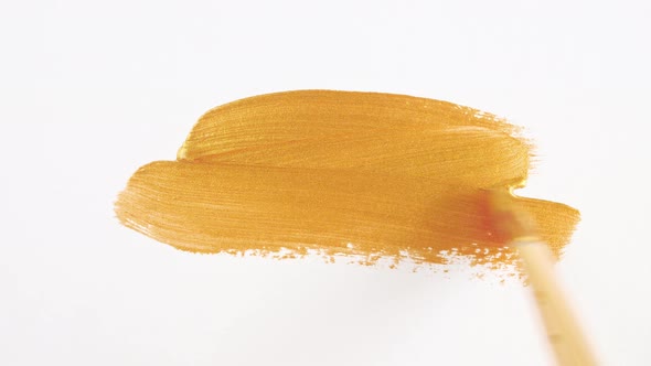 Abstract Brushstrokes of Gold Paint Brush Applied Isolated on a White Background