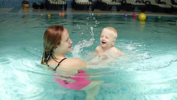 Cute Baby Having Swimming Lesson with His Mother