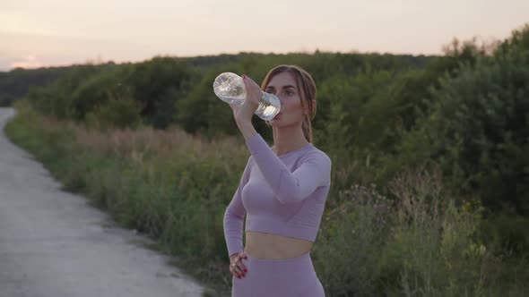 Slow Motion of a Girl That Drinks Water Outdoor