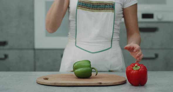 Woman with knife cutting Peppers